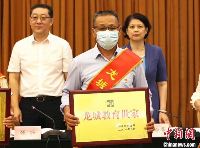 石玉辉展示“龙城教育世家”牌匾。 朱柳融 摄 石玉辉展示“龙城教育世家”牌匾。 朱柳融 摄