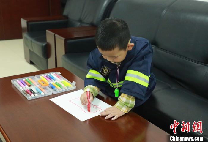 认真作画,向消防员叔叔表示谢意。 梁栋 摄 认真作画,向消防员叔叔表示谢意。 梁栋 摄