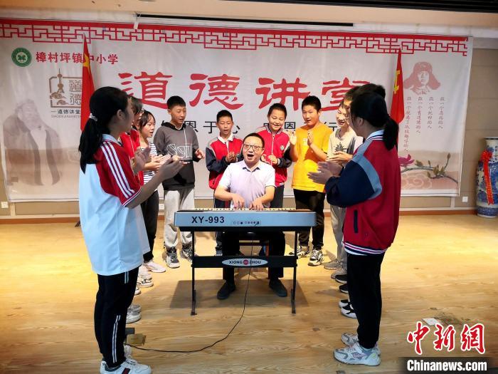 余良举给孩子们上音乐课。 樟村坪中小学供图 余良举给孩子们上音乐课。 樟村坪中小学供图