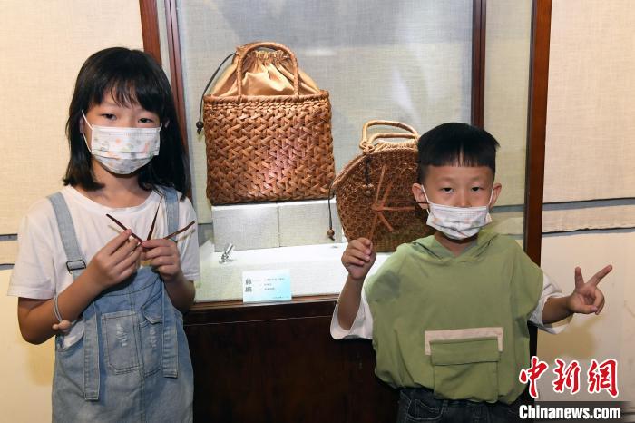 二位小朋友观众在展出的藤编艺术作品前留影。 记者刘可耕 摄 二位小朋友观众在展出的藤编艺术作品前留影。 记者刘可耕 摄