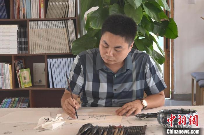 “榆木先生”庞志强在作画。 张俊 摄 “榆木先生”庞志强在作画。 张俊 摄
