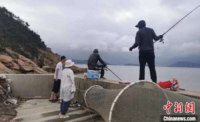 浙江温州洞头工作人员劝离垂钓人员。　潜浩杰 摄