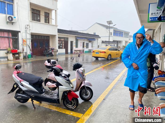塘头村村民风雨中出行 李典 摄 塘头村村民风雨中出行 李典 摄