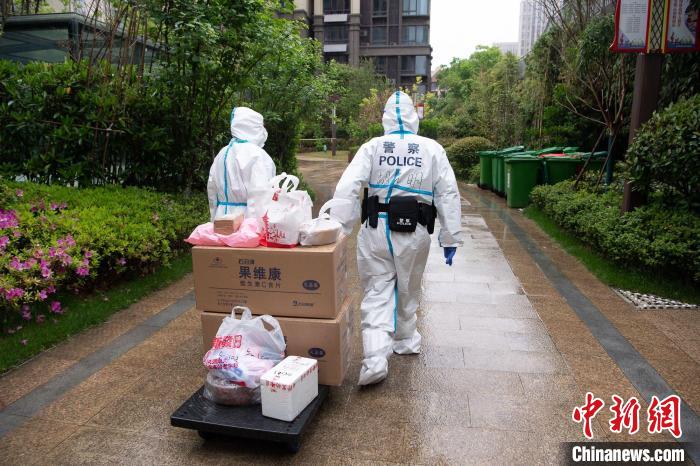 4月28日,合肥市公安局常青派出所民警胡光明(右一)在封控小区为居民运送物资。 宋军 摄 4月28日,合肥市公安局常青派出所民警胡光明(右一)在封控小区为居民运送物资。 宋军 摄