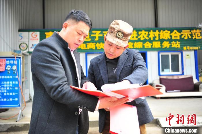 韩庆东与村干部查看工作台账。　张国荣 摄