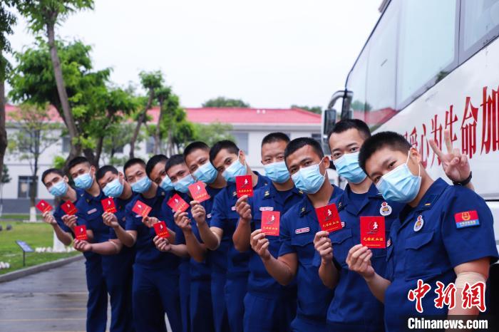 消防员展示献血证。　李袁辉 摄