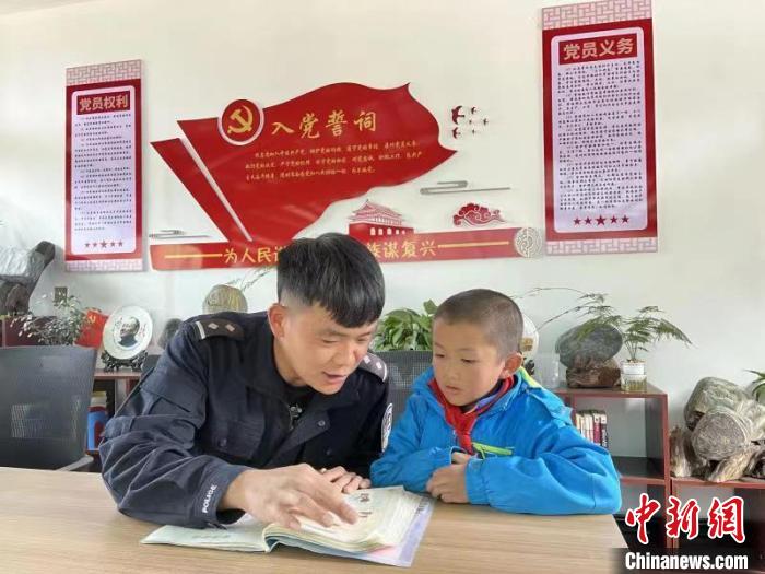 图为民警正在为留守儿童辅导作业。　怒江边境管理支队供图