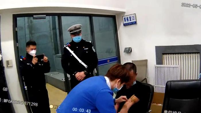 交警为酒驾男子验血取证。　哈市交警提供