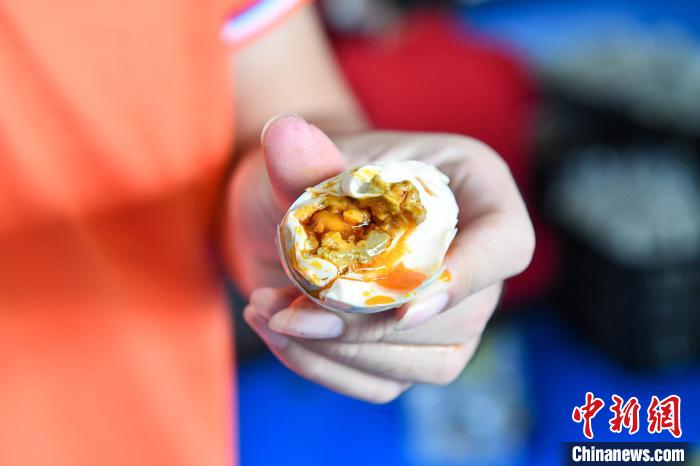 剥开当地生产的咸鸭蛋,蛋黄里的油流出来。凌楠 摄 剥开当地生产的咸鸭蛋,蛋黄里的油流出来。凌楠 摄