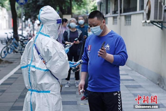 图为在昭化东路200弄门前临时核酸检测采样点，曹家堰居委会工作人员正在为市民登记信息。 殷立勤 摄