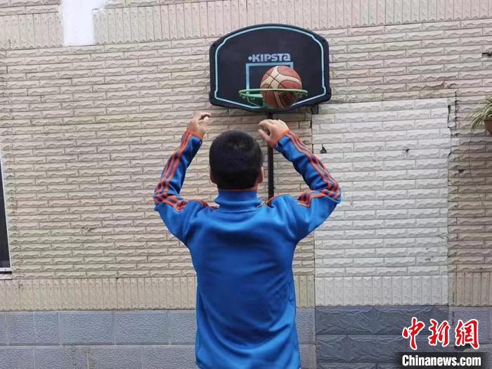 患有孤独症的孩子在校内玩球。　受访者供图