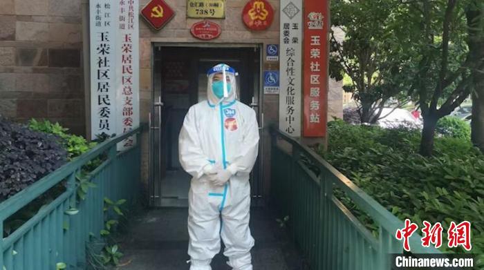 居委会工作人员黄超身穿“大白”在居民区门口留影 张践 摄