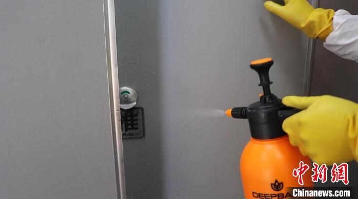 他们认真做好“一客一消杀”，及时清理污物垃圾，人体接触的水龙头、扶手、按钮等部位，做到人走即消杀 陈聪瑶 摄