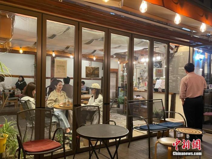当地时间4月18日，韩国公众聚集场所营业限时以及私人聚会、活动和集会限员等保持社交距离措施全面解除。图为市民当晚在首尔麻浦区一咖啡厅聚会。 <a target=