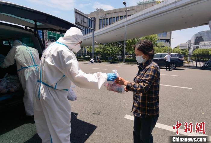工作人员向离沪旅客发放“爱心物资” 新虹街道供图 工作人员向离沪旅客发放“爱心物资” 新虹街道供图