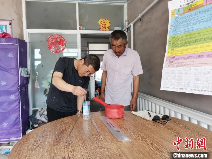 图为李旭光(左)指导王玉祥牛改良技术。　吕志敏 摄