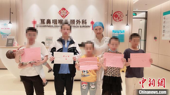 成功植入人工耳蜗的5名重度听障患儿与医护人员合影 潘增丽 摄 成功植入人工耳蜗的5名重度听障患儿与医护人员合影 潘增丽 摄