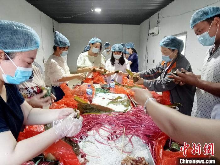 图为包粽子过程。　周渊 供图