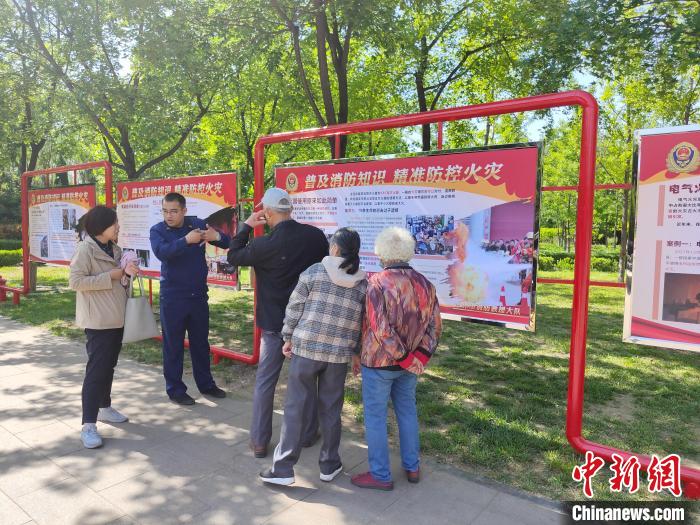 介休市消防救援大队制作“精准防控火灾”宣传版面，并派消防员为民众现场讲解。　师文宇 摄