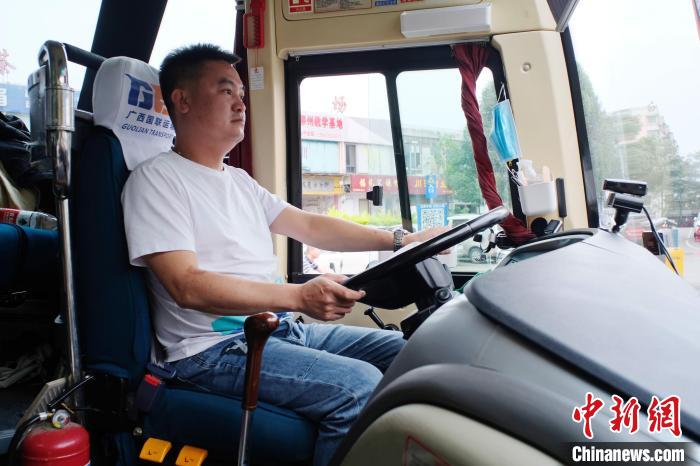 曾海波坐在”送考大巴“的驾驶座上。 刘俊聪 摄 曾海波坐在”送考大巴“的驾驶座上。 刘俊聪 摄