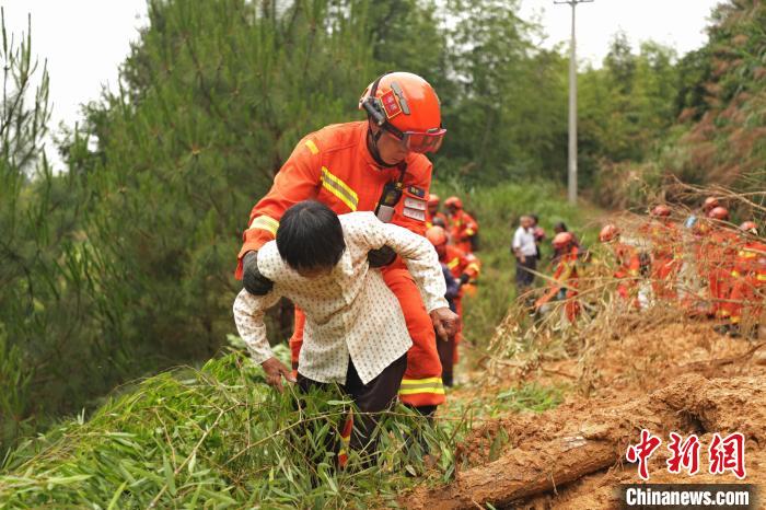森林消防队员搀扶老人通过险段。 吴皓 摄 森林消防队员搀扶老人通过险段。 吴皓 摄