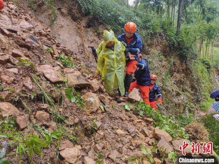 图为在转移过程中,救援人员搀扶村民走过险峻的路段。 司寒杰 摄 图为在转移过程中,救援人员搀扶村民走过险峻的路段。 司寒杰 摄