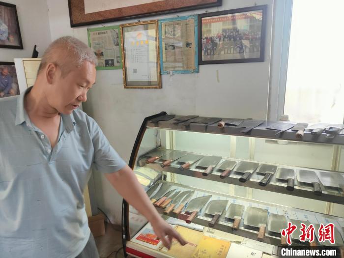 图为李记菜刀代表性传承人李留柱介绍菜刀的特点。　杨大勇 摄