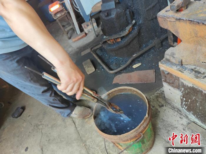 图为给刀坯淬火。　杨大勇 摄