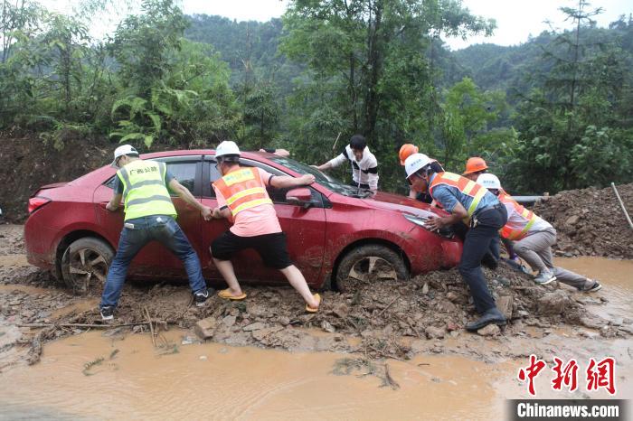 合力帮助群众受困车辆脱险。　陈乃文 摄
