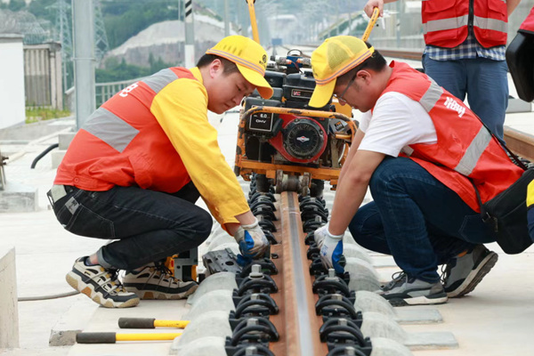 胡泽浩（左）与同事正在用轨检仪检测轨道各项几何尺寸。晏涛摄