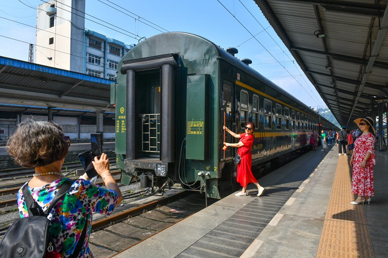 人们在重庆站和绿皮火车合影留念。邹乐 摄