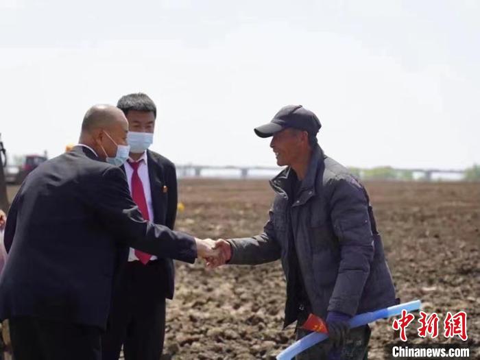 孙海鑫(左一)深入田间与乡亲交流。　受访者本人供图