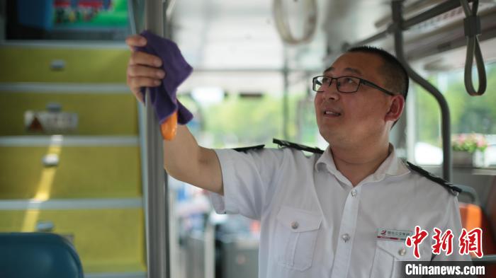 出发前，17路公交车司机在清洁车厢。　丁雷 摄