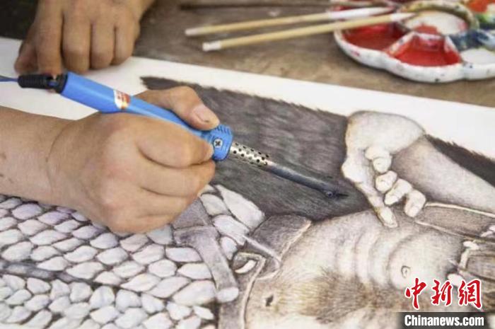 贾书辰在进行烙画创作 王春光 摄 贾书辰在进行烙画创作 王春光 摄