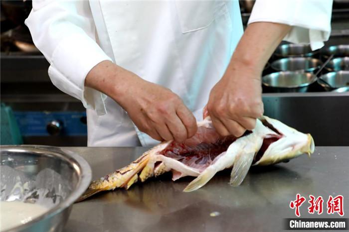 将鲤鱼的骨架用手掰至造型需要的弧度。 将鲤鱼的骨架用手掰至造型需要的弧度。