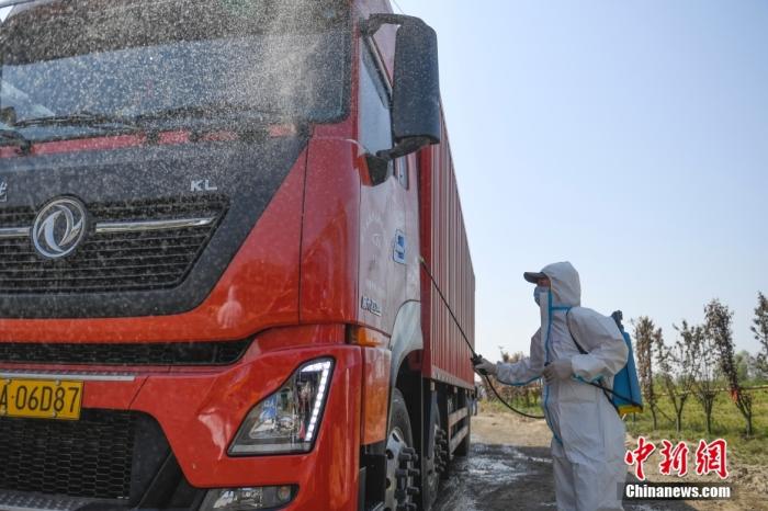 资料图：工作人员为进入接驳点的货车消杀。 <a target=