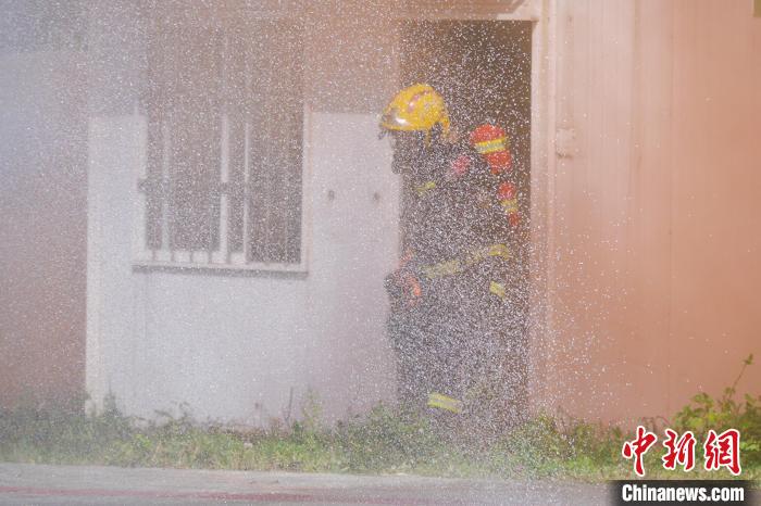 演练现场,消防队员将着火的液化石油气瓶搬离早餐店。 凌楠 摄 演练现场,消防队员将着火的液化石油气瓶搬离早餐店。 凌楠 摄