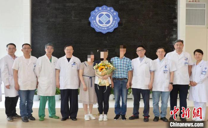 钱先生一家与江苏省人民医院党委书记唐金海教授、肝胆中心肝移植手术团队医护人员合影留念。 江苏省人民医院供图 钱先生一家与江苏省人民医院党委书记唐金海教授、肝胆中心肝移植手术团队医护人员合影留念。 江苏省人民医院供图