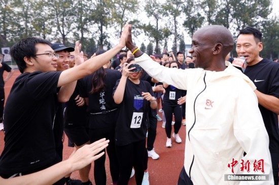10月12日，基普乔格(右二)在清华大学与学生跑友互动。<a target=